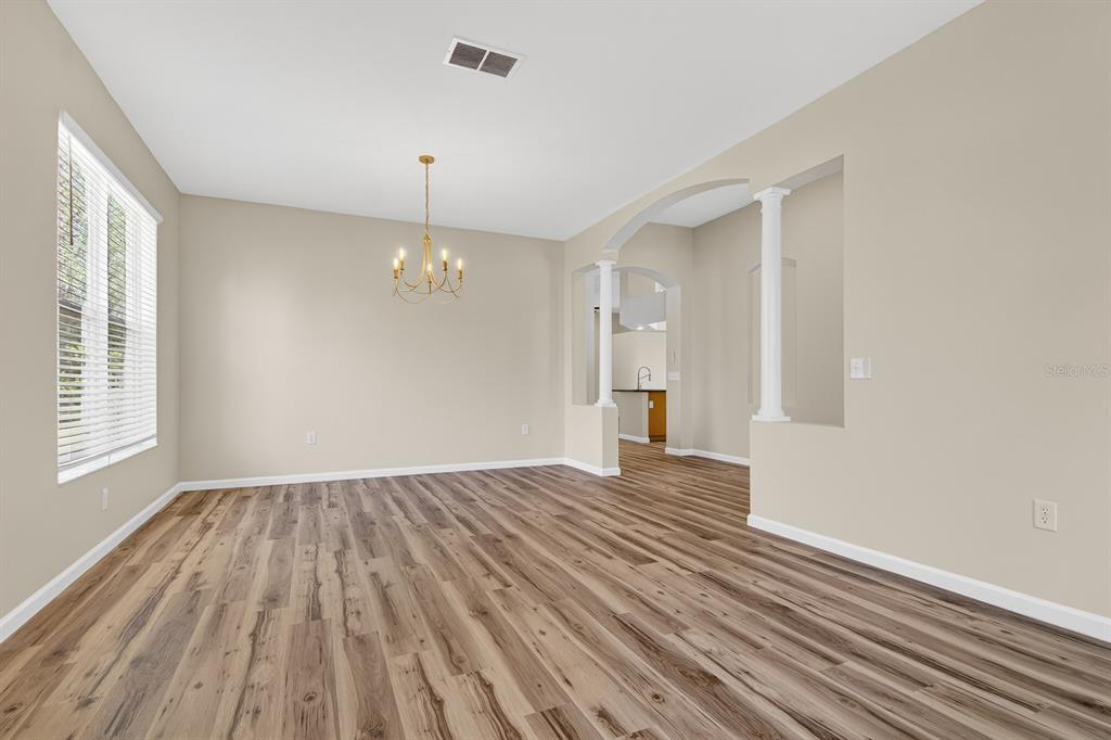 6002 Martinglade Place Lithia, FL 33547 - Photo 5 of 62 wooden floor in an empty room with a window
