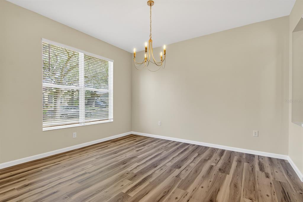 6002 Martinglade Place Lithia, FL 33547 - Photo 6 of 62 wooden floor in an empty room with a window