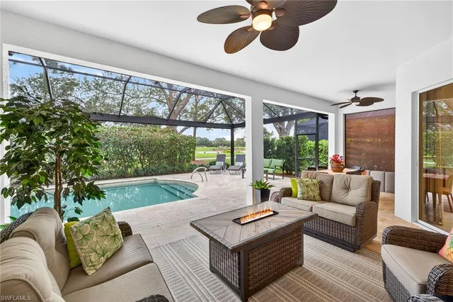 a living room with furniture ceiling fan and a large window