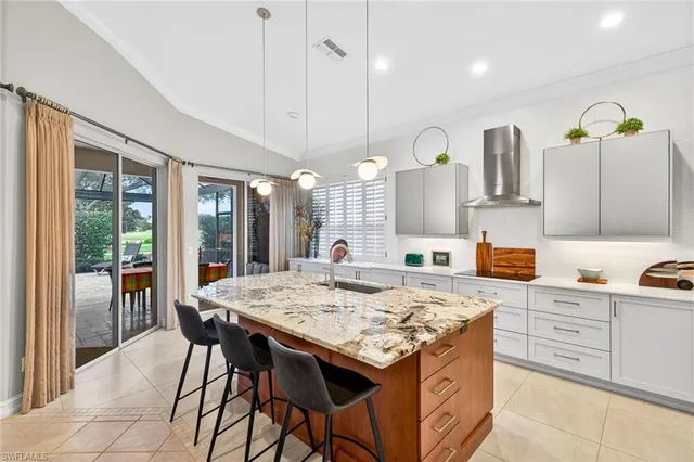 a kitchen with stainless steel appliances kitchen island granite countertop a table chairs and a wooden cabinets
