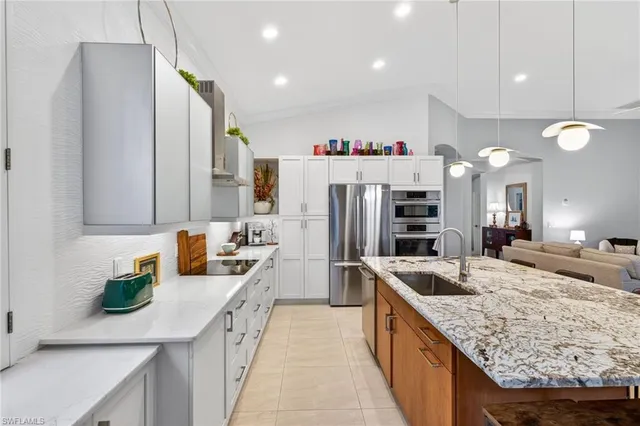 a kitchen with stainless steel appliances granite countertop a sink refrigerator and microwave