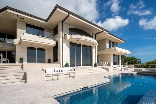 a view of a white building with swimming pool in front of it