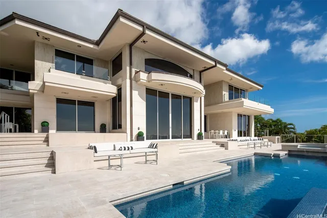 a view of a white building with swimming pool in front of it