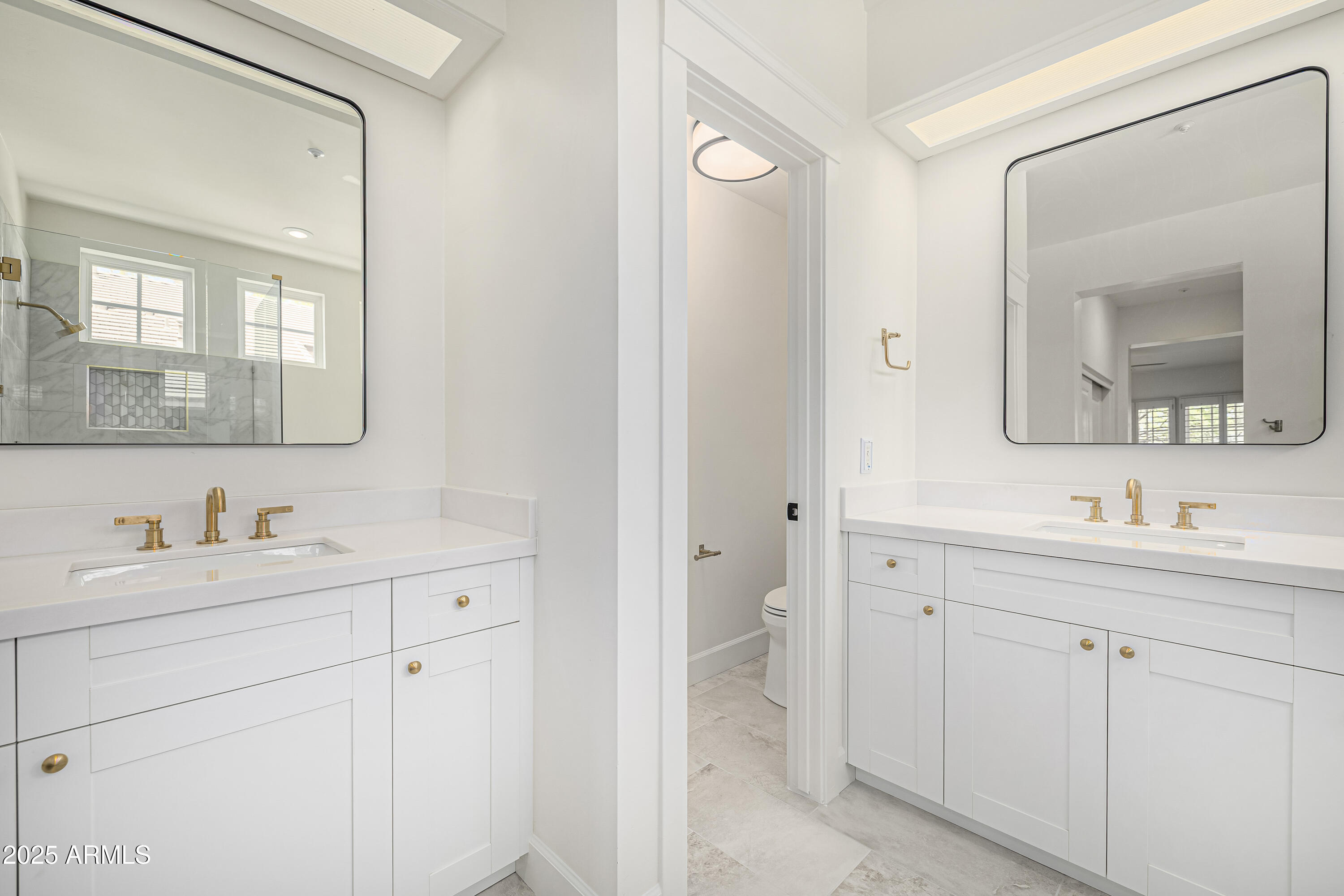 122 West Cottage Lane Tempe, AZ 85282 - Photo 23 of 43 a bathroom with a toilet a sink a mirror and wooden cabinets