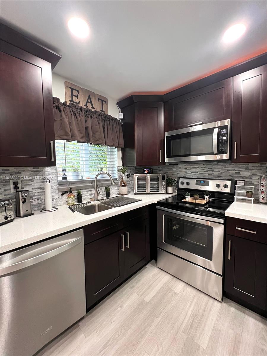 a kitchen with stainless steel appliances kitchen island granite countertop a sink and a stove
