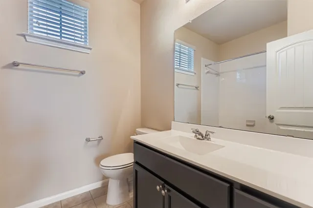 a bathroom with a granite countertop sink toilet and a mirror