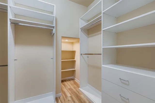 a view of walk in closet with empty racks