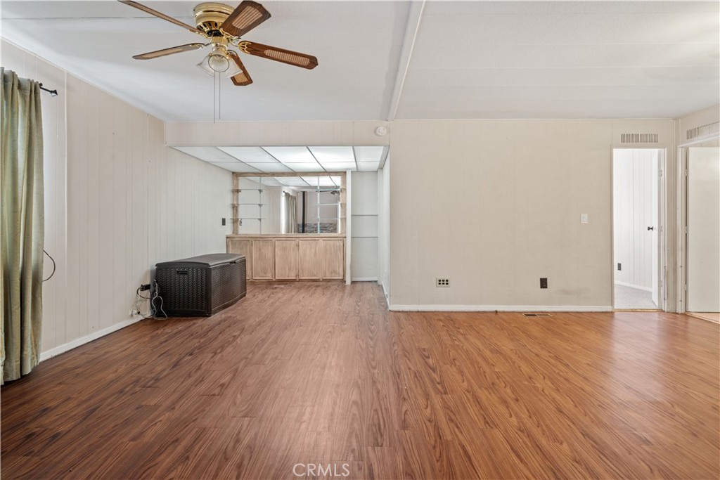 13393 Mariposa Road, Unit 169 Victorville, CA 92395 - Photo 11 of 36 a view of a livingroom with wooden floor and a ceiling fan