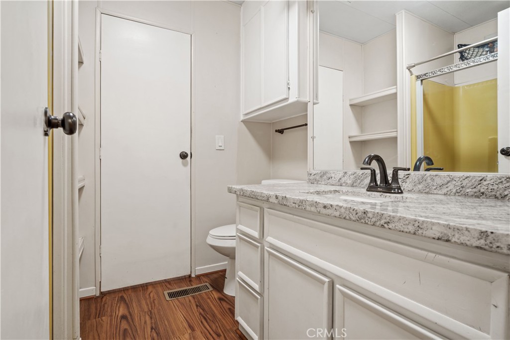 13393 Mariposa Road, Unit 169 Victorville, CA 92395 - Photo 18 of 36 a bathroom with a granite countertop sink toilet and a mirror