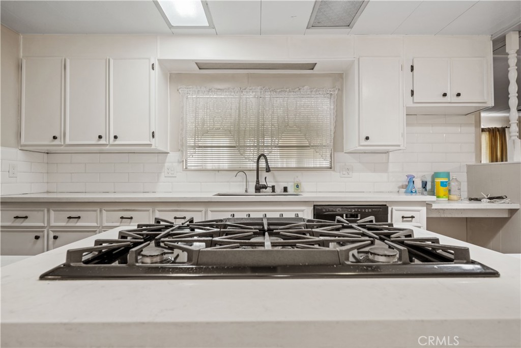 13393 Mariposa Road, Unit 169 Victorville, CA 92395 - Photo 5 of 36 a white kitchen stove with white cabinets and a stove