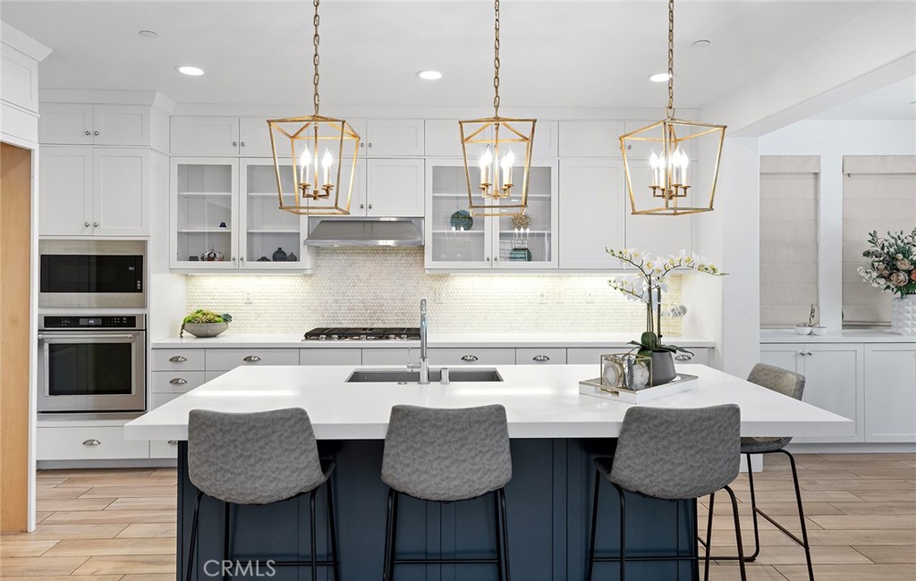 30 Windwalker Way Tustin, CA 92782 - Photo 3 of 22 a kitchen with stainless steel appliances granite countertop a stove a sink a microwave a dining table and chairs