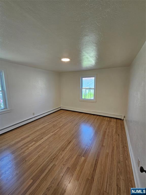 75 East Fort Lee Road, Unit 1 Bogota, NJ 07603 - Photo 5 of 8 an empty room with wooden floor and windows