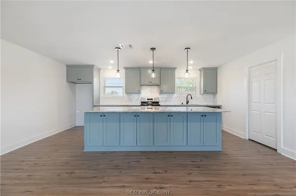 a kitchen with a sink cabinets and wooden floor