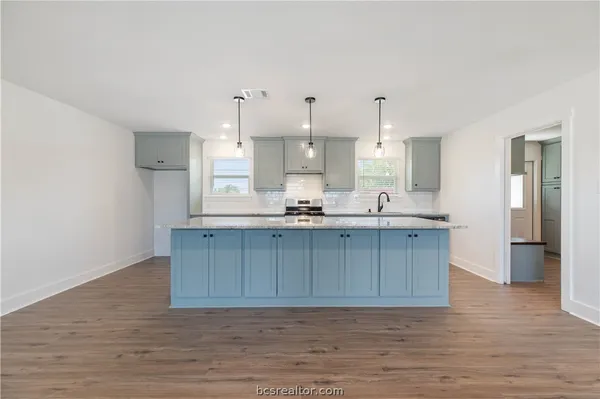 a kitchen with kitchen island white cabinets and refrigerator
