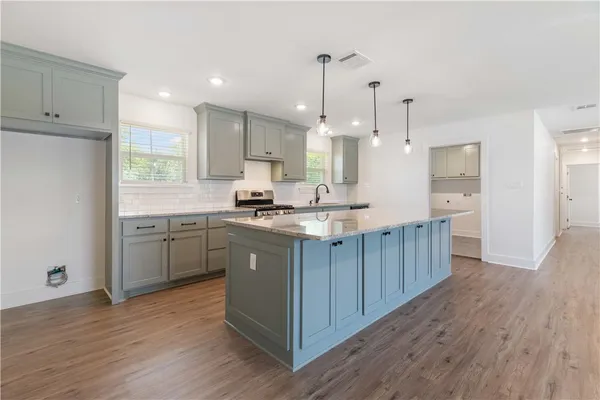 a kitchen with kitchen island a sink a center island stainless steel appliances and a window