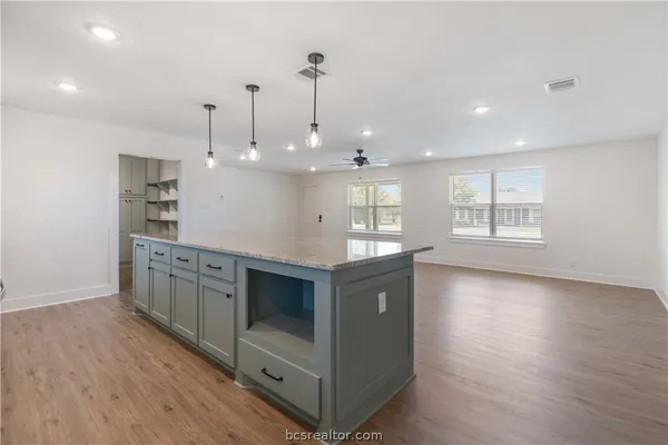 a kitchen with stainless steel appliances granite countertop a stove a sink and a wooden floors