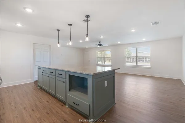 a kitchen with stainless steel appliances granite countertop a stove a sink and a wooden floors