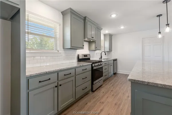 a kitchen with granite countertop white cabinets and white appliances