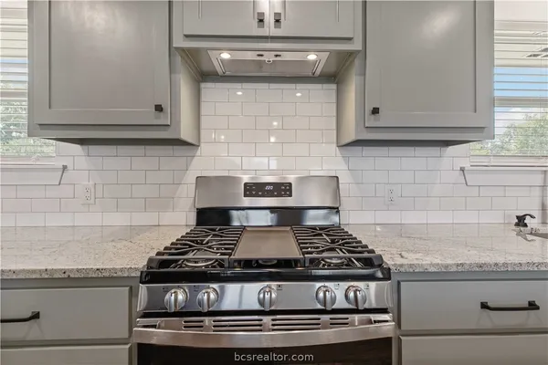 a stove top oven sitting inside of a kitchen