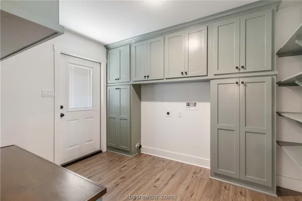 an empty room with wooden floor and cabinets