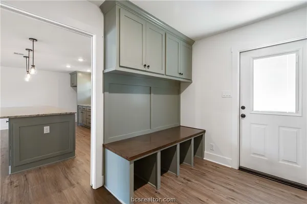 a kitchen with white cabinets and wooden floor