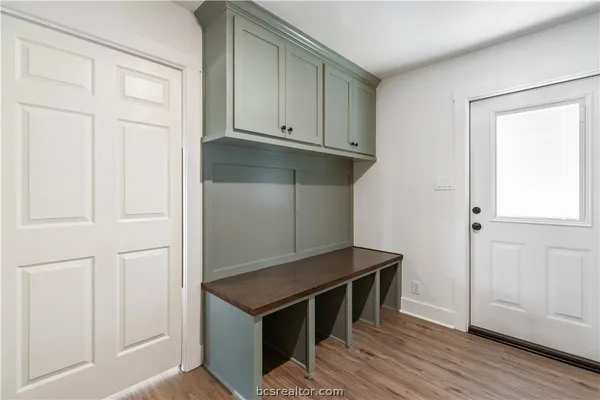 a kitchen with white cabinets and wooden floor