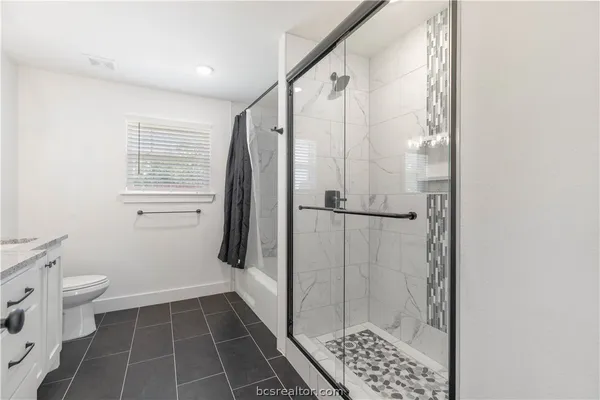 a bathroom with a shower and a toilet