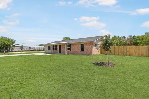 a front view of house with a garden