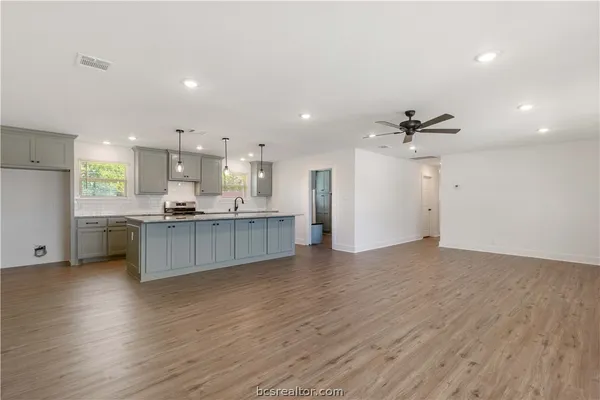 a view of kitchen with kitchen island white cabinetry and wooden floor