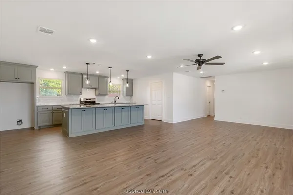 a view of kitchen with kitchen island white cabinetry and wooden floor