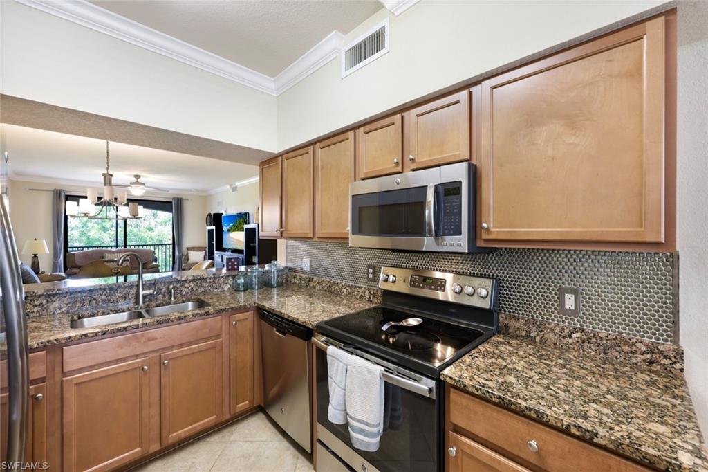 Undisclosed Address Naples, FL 34113 - Photo 6 of 24 a kitchen with stainless steel appliances granite countertop a sink stove and microwave