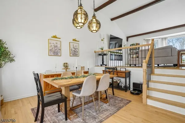 a view of a dining room with furniture a chandelier and wooden floor