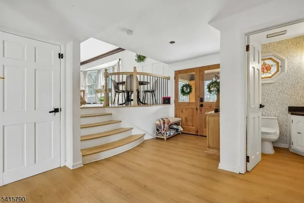 a view of a hallway with bathroom and wooden floor