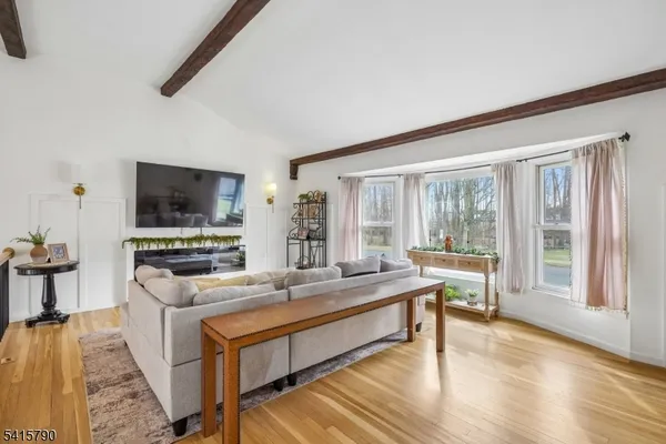 a large living room with stainless steel appliances granite countertop a stove and a flat screen tv