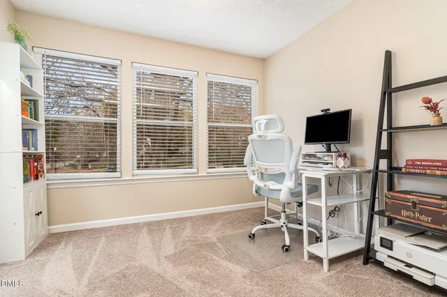 a view of a workspace with furniture and a window