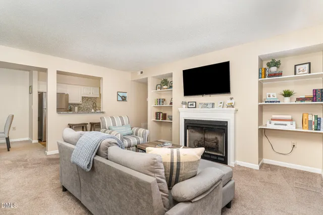 a living room with furniture a fireplace and a flat screen tv