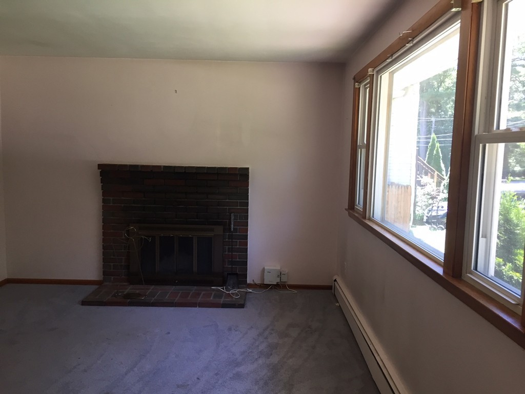 70 Bellflower Road Billerica, MA 01821 - Photo 8 of 23 a living room with a fireplace and a large window