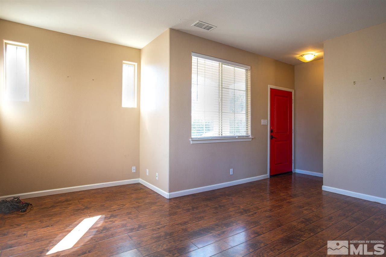 9765 Meadowstar Drive Reno, NV 89506 - Photo 3 of 21 an empty room with wooden floor and windows