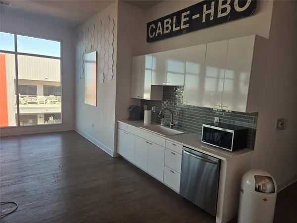 a kitchen with granite countertop a stove a sink and a microwave