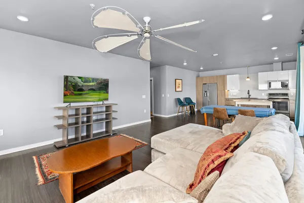 a living room with furniture kitchen view and a flat screen tv