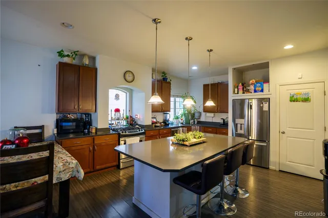 a kitchen with a refrigerator a sink and chairs