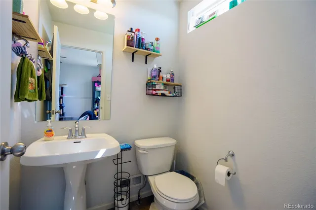 a bathroom with a sink mirror and toilet