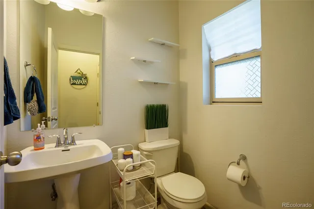 a bathroom with a toilet a sink and mirror