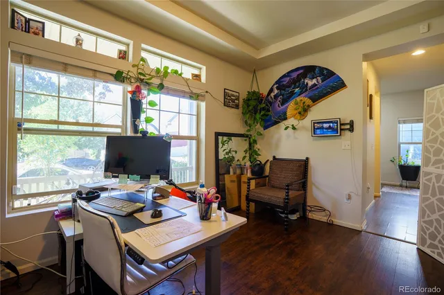 a view of a workspace with furniture and a window
