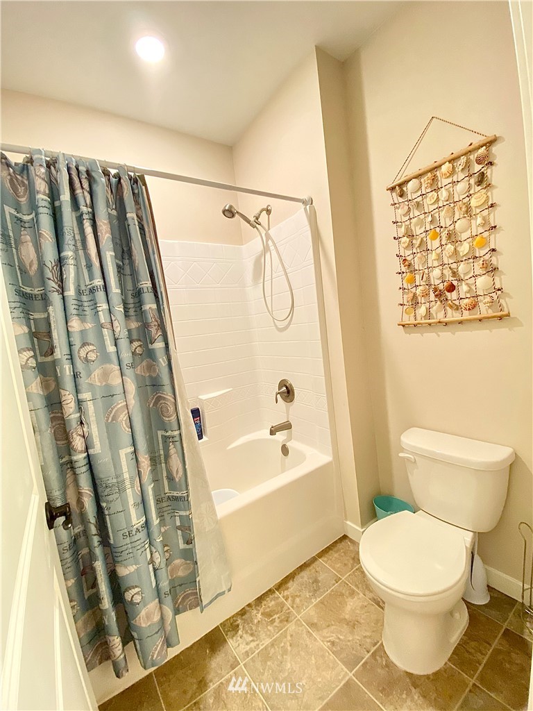 22004 Lee Road Southwest Centralia, WA 98531 - Photo 11 of 26 a bathroom with a toilet and a shower curtain