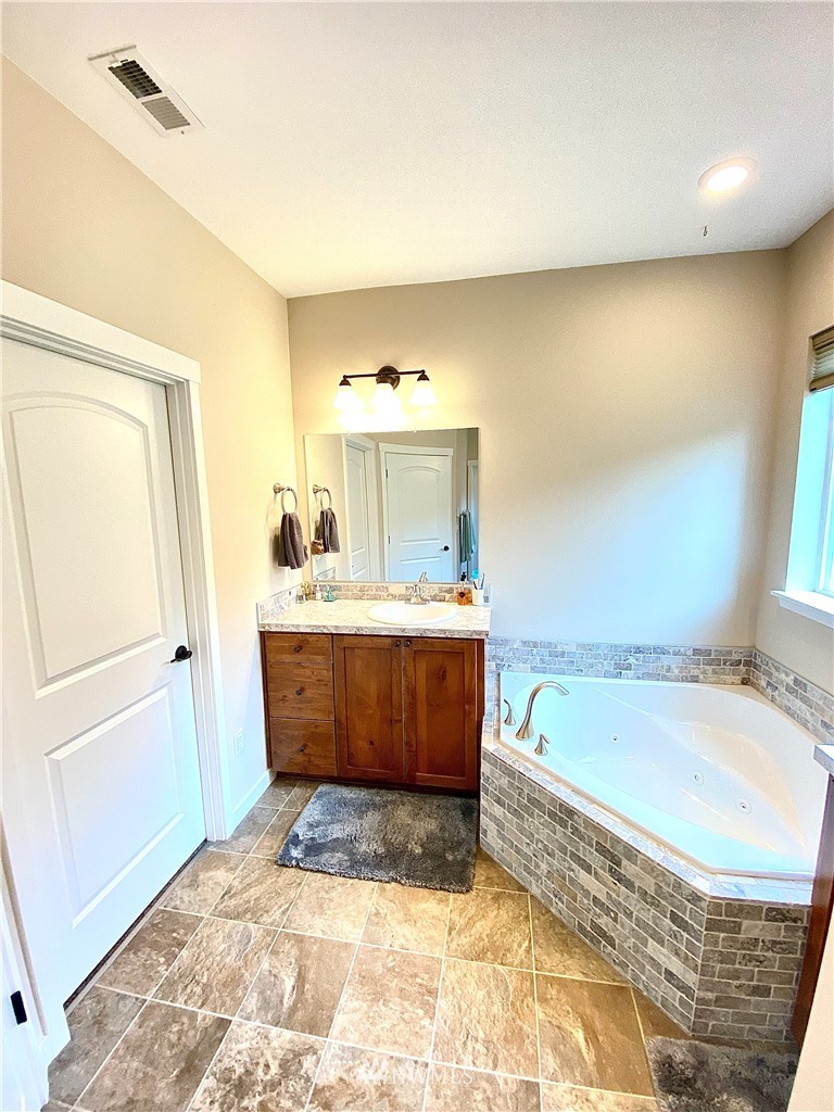 22004 Lee Road Southwest Centralia, WA 98531 - Photo 16 of 26 a bathroom with a tub sink and mirror
