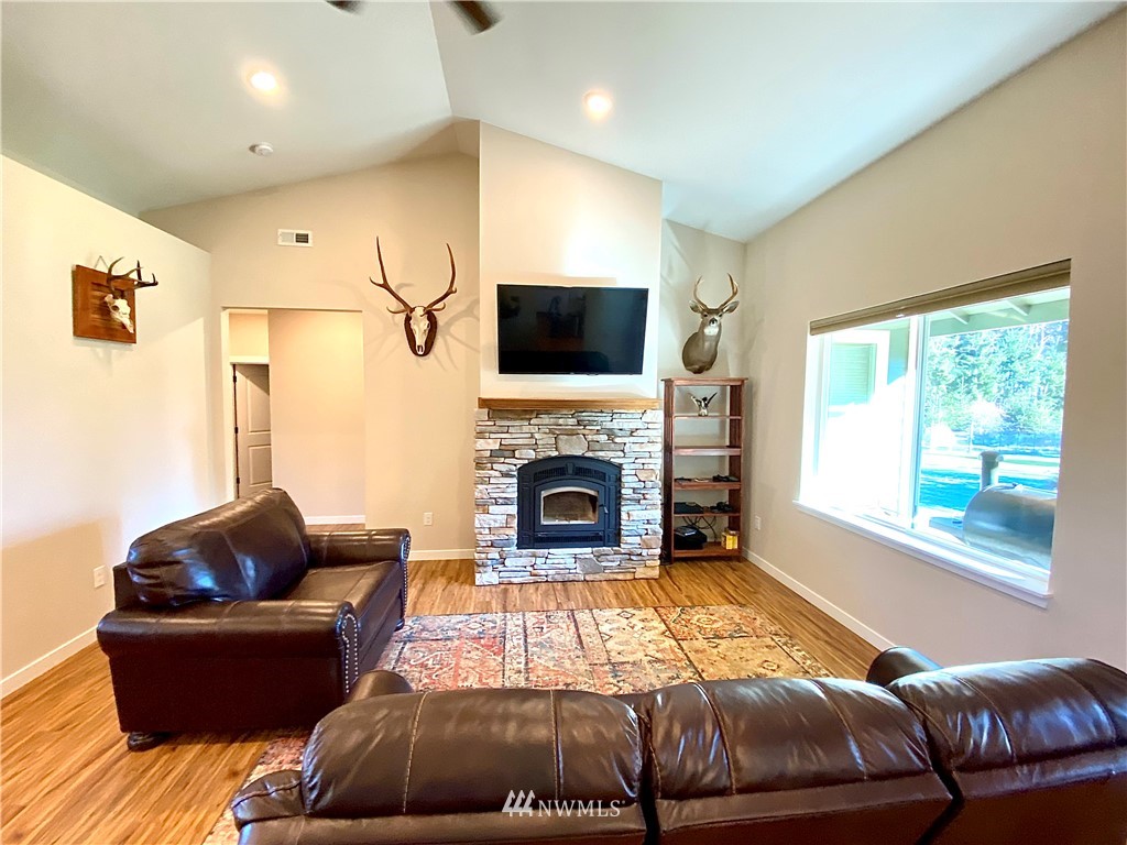 22004 Lee Road Southwest Centralia, WA 98531 - Photo 5 of 26 a living room with furniture a flat screen tv and a fireplace