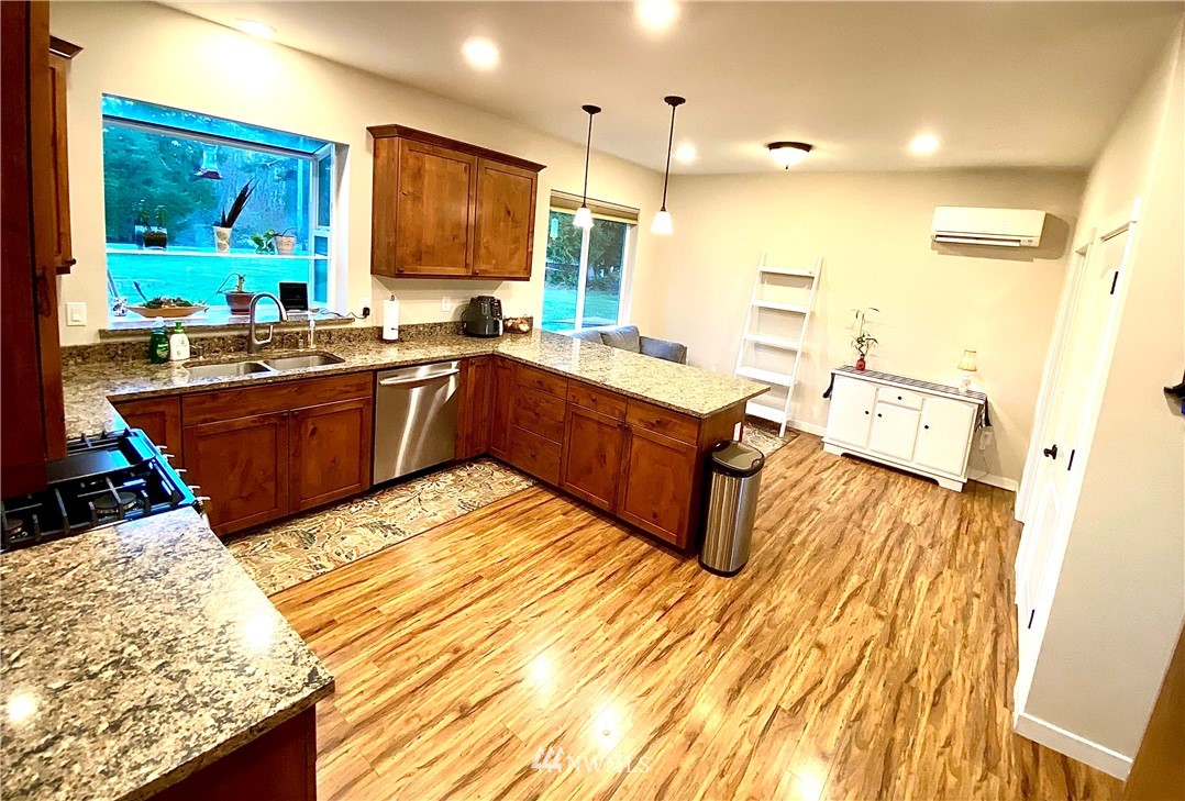 22004 Lee Road Southwest Centralia, WA 98531 - Photo 6 of 26 a large kitchen with stainless steel appliances granite countertop a sink dishwasher and a black countertop with white cabinets