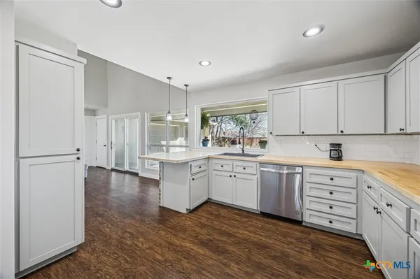 a kitchen with white cabinets and sink