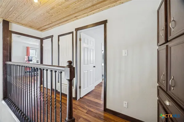 a view of a hallway with wooden floor and staircase